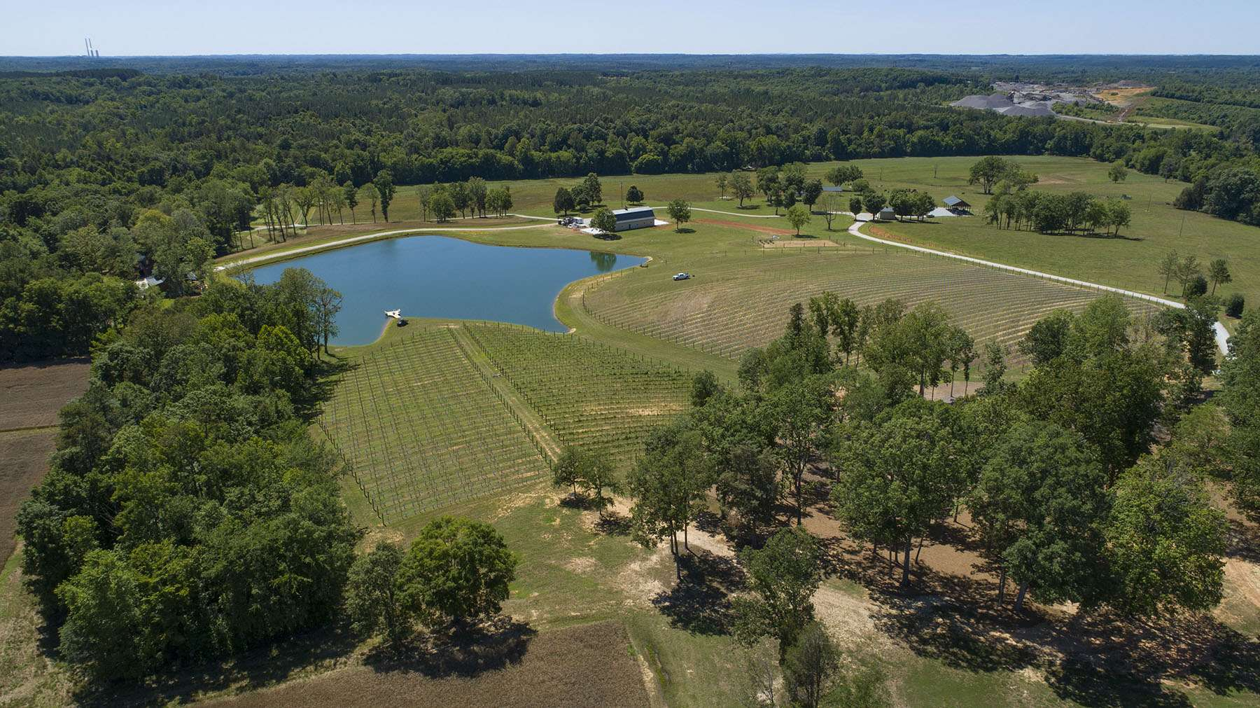 Aerial view of the vineyard estate with pond and rolling hills